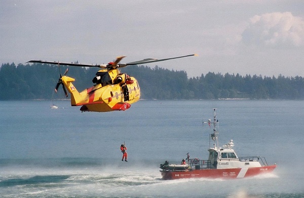  A Canadian Forces CH-149 Cormorant helicopter hoists a man from a Canadian Coast Guard cutter. 